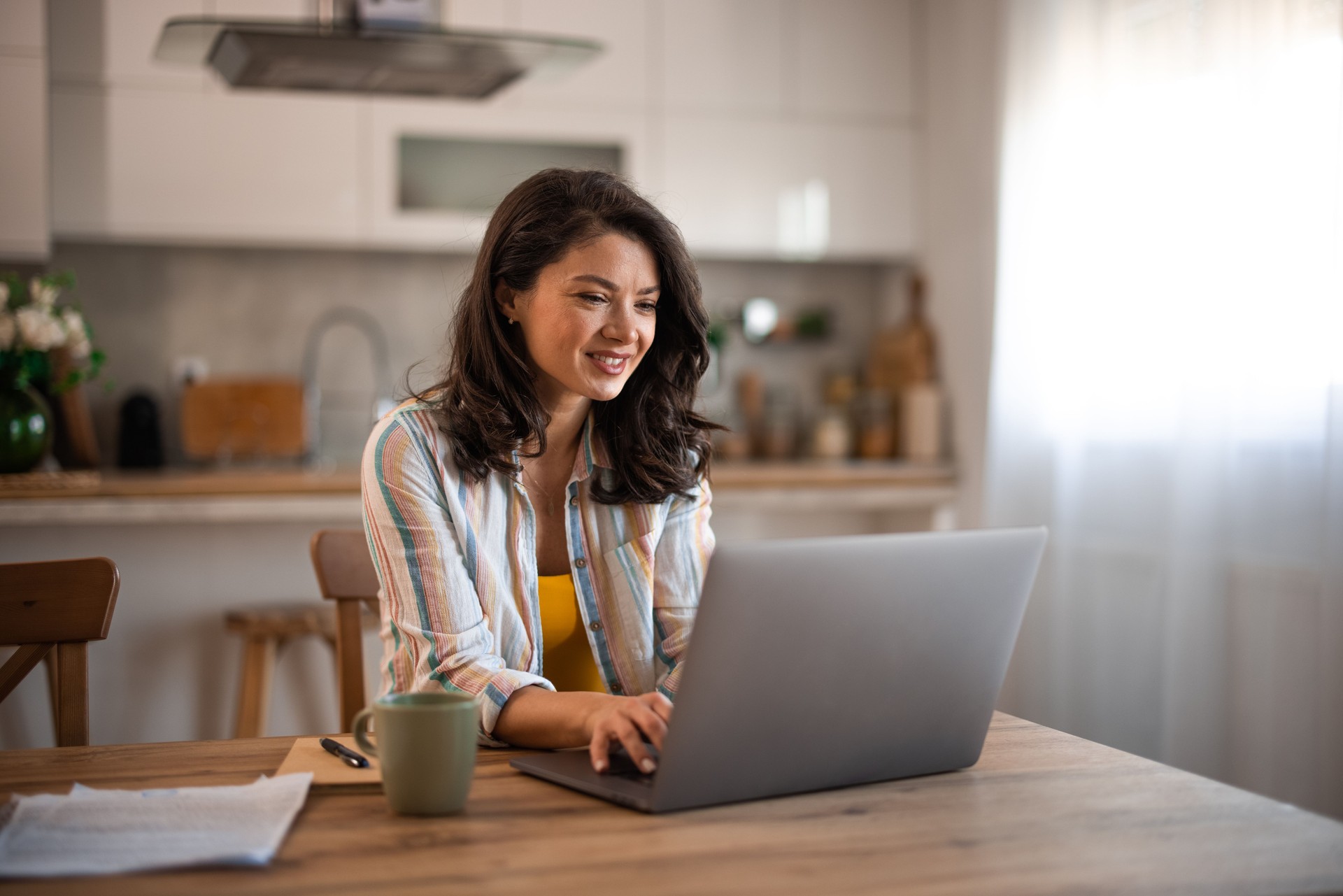 Portrait of middle aged woman sitting at home with laptop working at home